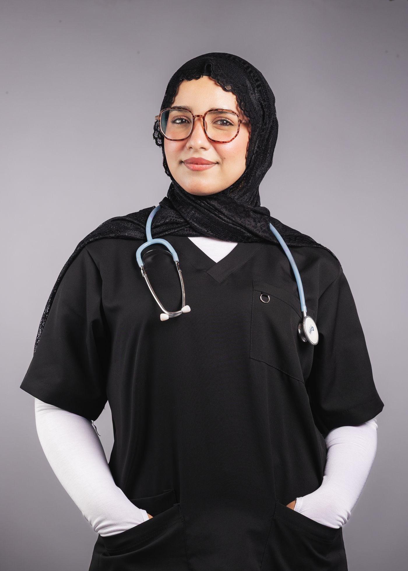 An Arab female doctor wearing a hijab, medical scrubs, and a stethoscope
